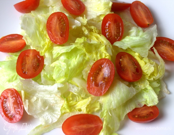 На тарелку порвать листья салата. Сверху кладем помидоры черри.