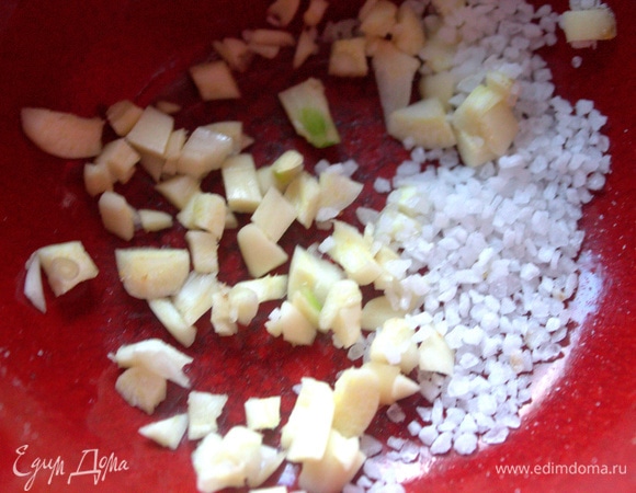 В ступку или пиалку положить измельченный чеснок, насыпать морскую соль.