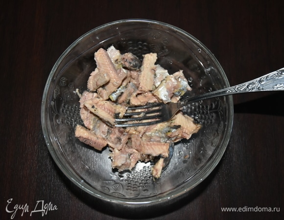 Рыбу выложить в миску, освободить от крупных костей и размять вилкой.