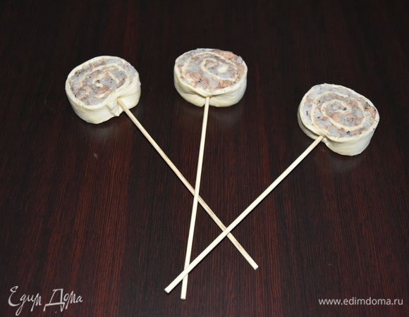 Каждую улитку насадить на деревянную шпажку. Для пикантности можно посыпать их различными специями: кунжутом, паприкой, чили, розмарином и т. д. Разложить завитушки на противне, застеленном пергаментной бумагой. Выпекать минут 15–20 при температуре 180–200°C.
