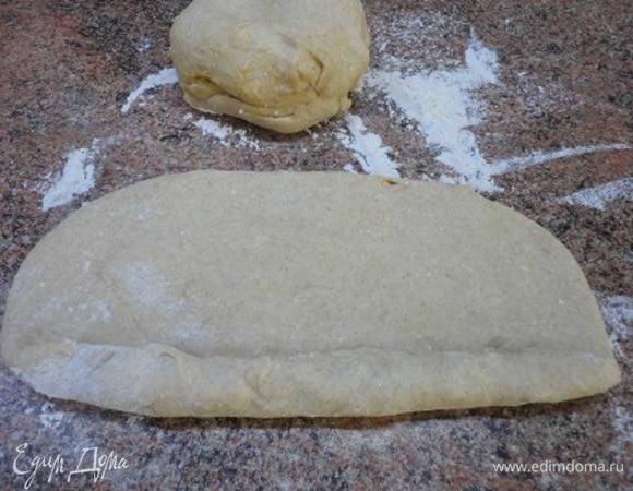 Подошедшее тесто делим на три равные части. Каждую раскатываем в овал и сворачиваем рулетом, всякий раз плотно приминая тесто.