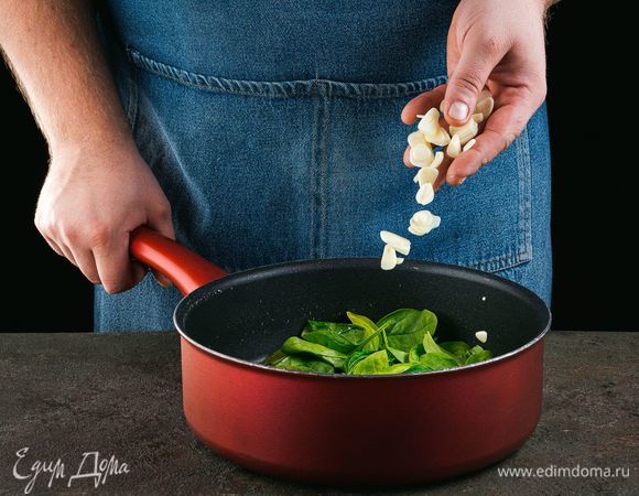 Промойте шпинат и нарежьте чеснок. Обжарьте на сковороде в оливковом масле чеснок и шпинат.