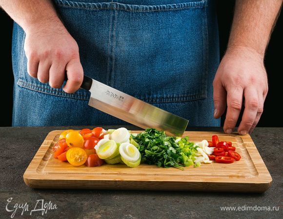 Чеснок мелко нарежьте, лук-порей и чили нарежьте кольцами, помидоры — пополам.