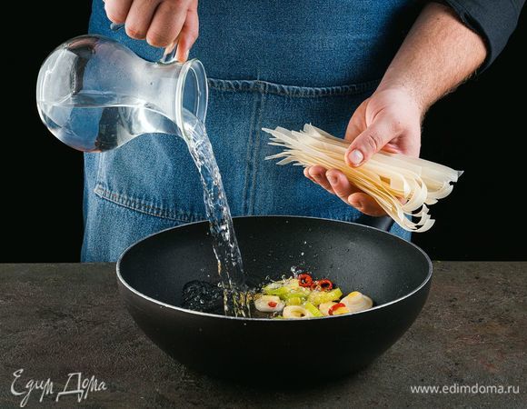 Залейте все горячей водой. Добавьте рисовую лапшу. Дождитесь закипания, посолите и поперчите. 