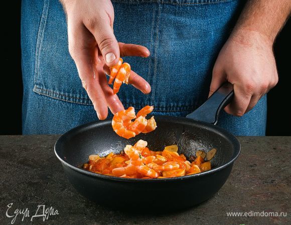 На сковороде обжарьте на оливковом масле чеснок и помидоры. Добавьте креветки королевские ТМ «Капитан Вкусов».