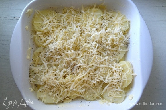 Посыпать картофель 1/3 натертого сыра.