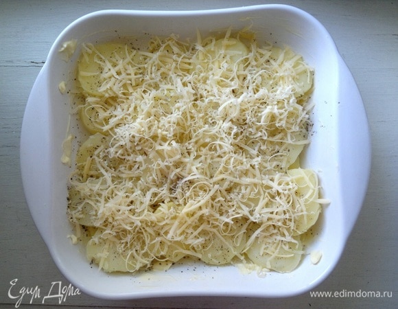 Посыпать картофель 1/3 натертого сыра.