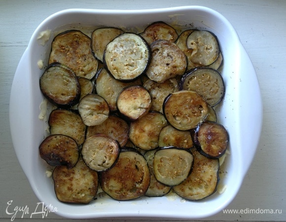 Обжаренные кружки баклажанов выложить в форму. Немного посолить, поперчить.