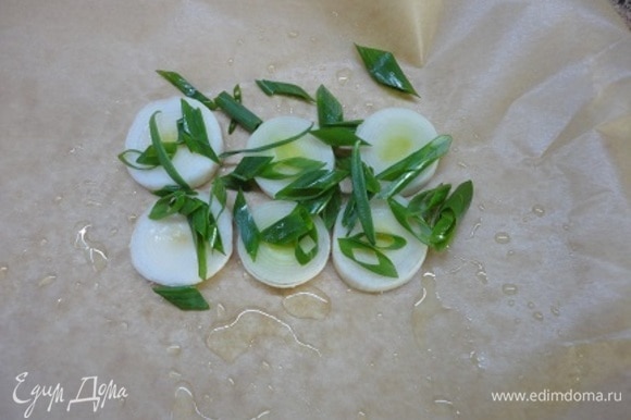 Каждое филе (примерно 200 г) будем запекать отдельно в пергаменте. Смажьте каждый лист пергамента оливковым маслом, выложите кружочки белой части лука-порея и одно перо нарезанного зеленого лука.