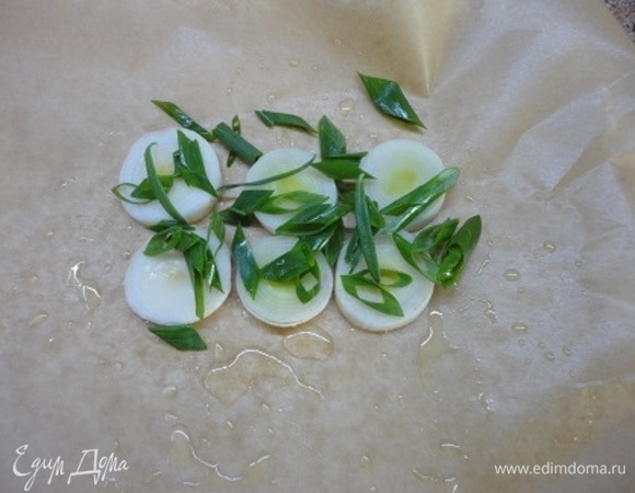 Каждое филе (примерно 200 г) будем запекать отдельно в пергаменте.<br />
Смажьте каждый лист пергамента оливковым маслом, выложите кружочки белой части лука-порея и одно перо нарезанного зеленого лука.