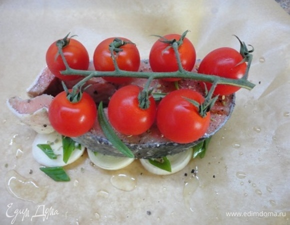 Каждый порционный кусочек рыбы натрите солью, свежемолотым перцем и уложите на лук. По желанию можете посыпать любимыми травами. Я использовала сухой орегано и несколько листиков свежего розмарина (он у меня в горшке растет). Сверху укладываем веточку томатов черри и сбрызгиваем оливковым маслом.