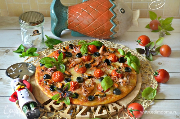Подавать готовую пиццу лучше горячей, украсив листиками базилика. На природе приготовленную пиццу слегка сбрызните водой, оберните в фольгу, разместите на решетку и быстро разогрейте над раскаленными углями. Приятного вам аппетита!