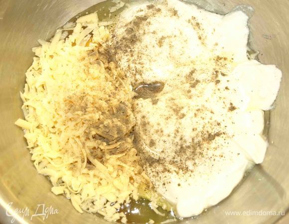 Все продукты комнатной температуры, кроме сливочного масла (его легче будет резать кусочками охлажденным). В миске соединить яйца, йогурт, сметану, измельченный на терке сыр, соль, перец. Все хорошо перемешать.