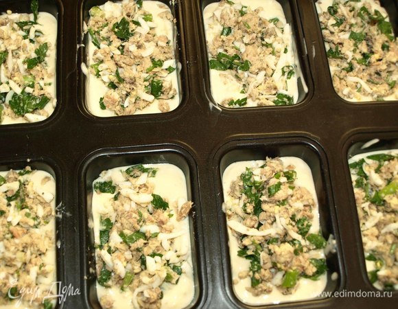 Можно приготовить один большой пирог, а можно приготовить порционные пироги в формочках для кексов. Формочки смазать растительным маслом, дно выложить пекарской бумагой (по размеру дна формы). Выкладываем столовую ложку теста в формочку (зависит от размера формочек). На тесто выкладываем начинку.