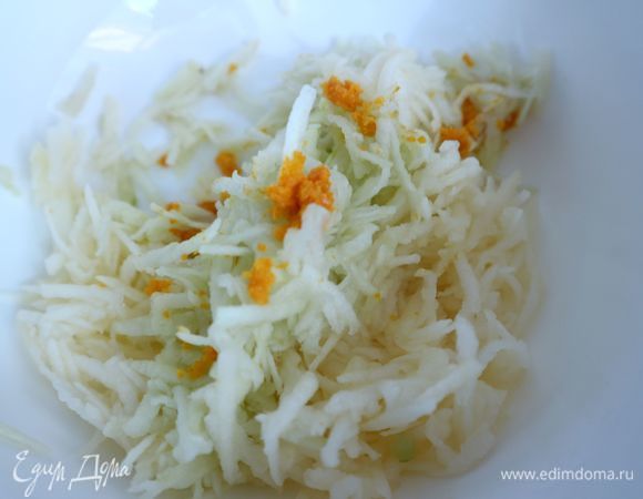 Духовку разогреть до 190°C. Дно формы накрыть бумагой для выпечки. Борта формы хорошо смазать сливочным маслом (5 г). Натереть на мелкой терке цедру апельсина. Натереть на крупной терке в отдельную миску 1/3 часть очищенных от кожуры яблок, перемешать с 1/3 частью цедры. Яблоки советую чистить для каждого слоя пирога отдельно, чтобы они меньше темнели. Всего в пироге четыре слоя сухой смеси и три слоя яблок.