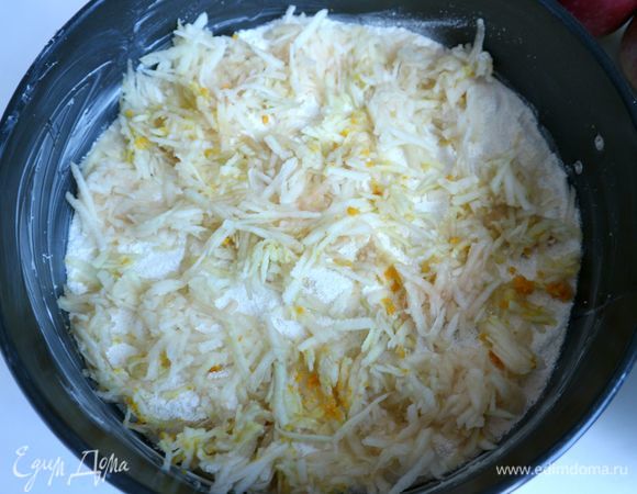 Часть сухой смеси (примерно 1/4) поместить равномерно на дно формы. Смесь не приминать. Яблоки (1/3 часть от общего количества) с частью цедры поместить равномерно на сухую смесь в форму.