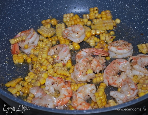 Добавьте креветки, обжарьте их в течение двух минут и добавьте кукурузу. Все вместе перемешайте и обжарьте.