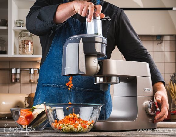 Промойте все овощи и обсушите бумажными полотенцами. Установите на кухонную машину KENWOOD насадку для нарезки кубиками. С ее помощью нарежьте баклажан, болгарский перец и цукини.