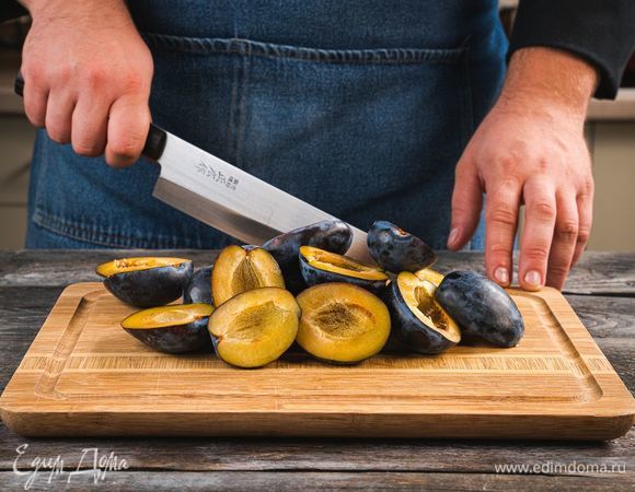 Промойте сливы, обсушите, разрежьте пополам и извлеките косточки.