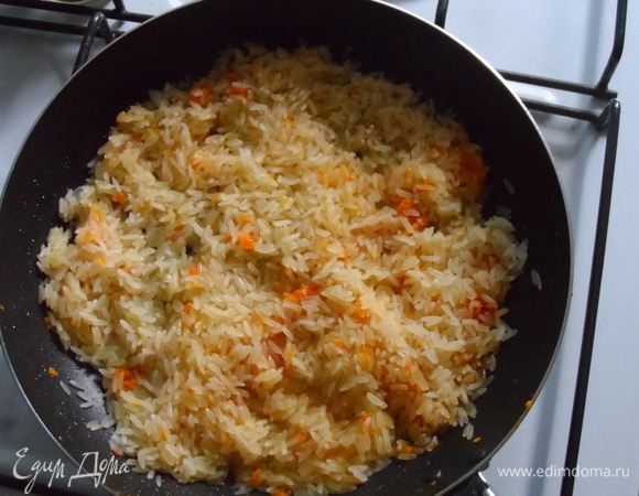Добавить рис и жарить, пока не выпарится вода.