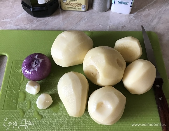 Духовку нагреть до 200°C. Картофель, лук и чеснок очистить.