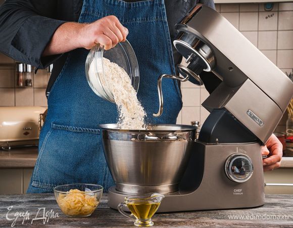 В чашу кухонной машины добавьте лук и 1 ст. л. оливкового масла. С помощью насадки для смешивания хорошо перемешайте ингредиенты. Далее используйте насадку крюк, чтобы замешать тесто. Постепенно добавляйте муку, чтобы получилось мягкое, слегка прилипающее к рукам тесто и замесите тесто с помощью насадки крюк. Поставьте тесто на расстойку в теплое место на 1 час.