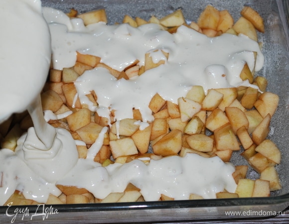Форму смажьте маслом, выложите нарезанные яблоки и сверху залейте тестом.