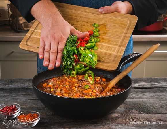 Добавьте в сотейник перец чили, чеснок и кинзу. Налейте в сотейник воду, чтобы она слегка покрывала его содержимое. Посолите и поперчите по вкусу.
