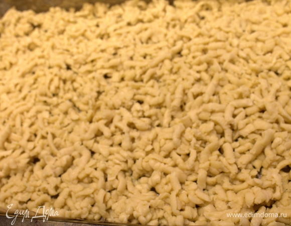 Большую часть достать, когда тесто станет тверже, и натереть на крупной терке на противень или в форму. Можно запечь основание минут 5–7 без варенья. Запекала в электрической духовке при 250°C.