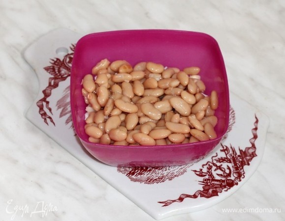 Из консервированной фасоли слить жидкость, промыть и добавить в миску.