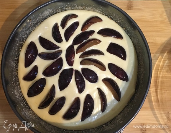 Равномерно раскладываем на тесто половину слив.