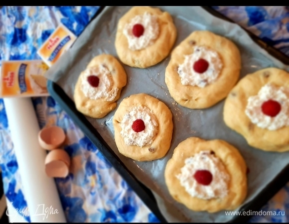 Противень застелить пекарской бумагой, смазать маслом. Разделить тесто на шарики и уложить на противень. В серединке сделать углубление стаканчиком и уложить подготовленную маленькую начинку. Украсить сверху ягодой. Смазать желтком ватрушки и отправить в духовку выпекаться на 20–25 минут при температуре 180°C. Ватрушки уложить на расстоянии, так как тесто еще поднимется, и ватрушки увеличатся в объеме.