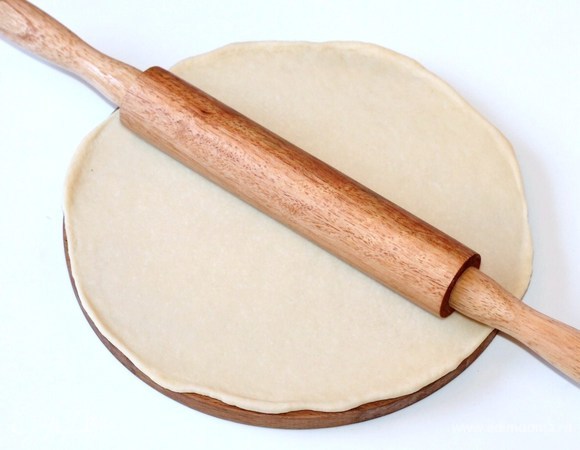 Каждый шарик раскатать в круг диаметром 24 см. Если остались маленькие обрезки, кладем под пленку — из них сформируем серединку пирога.