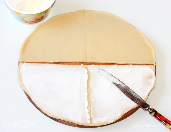 Разделить каждый круг пополам. В каждой половинке круга отметить (но не резать) середину. Смазать половинки круга творожным сыром.