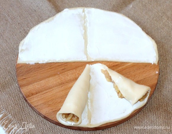 Равномерно сворачиваем тесто с обеих сторон полукруга так, чтобы два рожка встретились в середине.