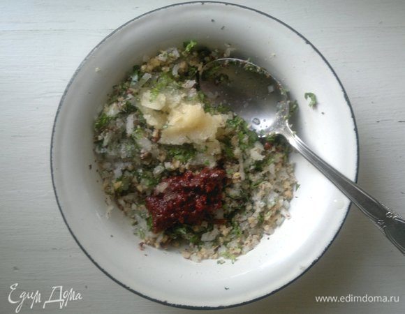 В миске соединить орехи, лук, кинзу. Добавить аджику, пропущенный через пресс чеснок, соль по вкусу, белый виноградный уксус, перемешать. Добавляя по одной столовой ложке воды, растереть массу до состояния пасты. Воды может потребоваться больше или меньше.