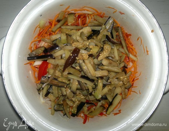 Выложить баклажаны вместе с горячим маслом в кастрюлю к овощам, перемешать.