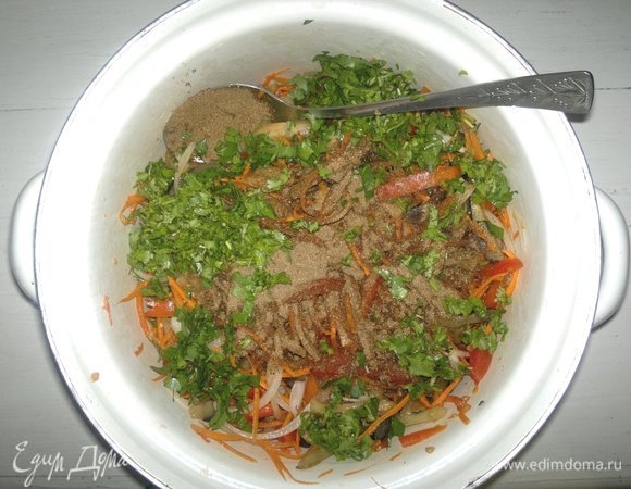 В кастрюлю с овощами добавить нарезанную зелень, всыпать сухую приправу для моркови по-корейски, перемешать. Поставить салат в холодильник на 1–2 суток. Периодически перемешивать.