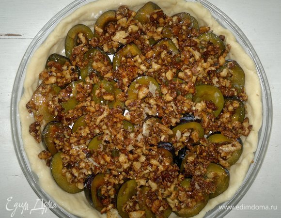 Горячую ореховую массу выложить в форму на сливы. Поставить пирог в духовку, разогретую до 180°C, на 30–35 минут.