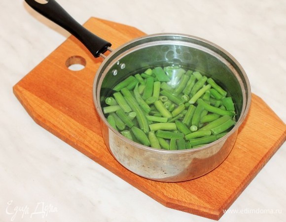 Поместить в кипящую воду стручковую фасоль, довести до кипения и варить до готовности. Затем слейте воду и охладите фасоль.