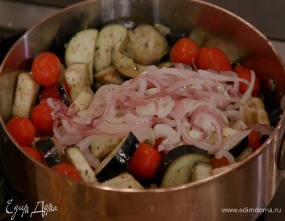 В глубокой сковороде разогреть 3‒4 ст. ложки оливкового масла, выложить баклажаны и помидоры черри, слегка посолить, посыпать орегано и чили, добавить обжаренный лук с чесноком, все перемешать.