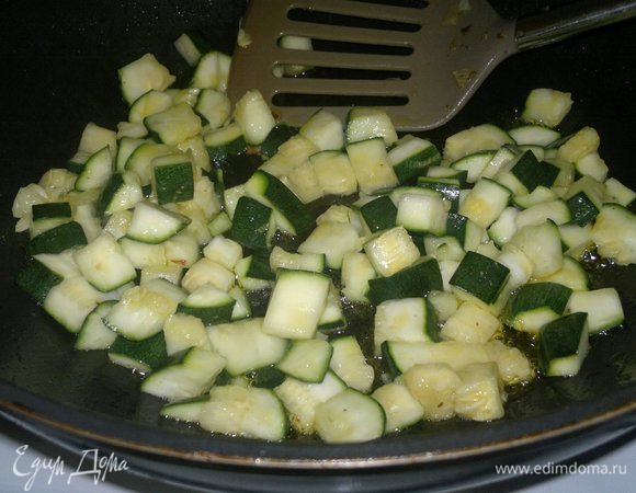 С цукини слить образовавшийся сок, обсушить. Обжарить цукини на оставшемся масле. Выложить на сито для стекания масла, затем соединить с тилапией, луком и морковью.