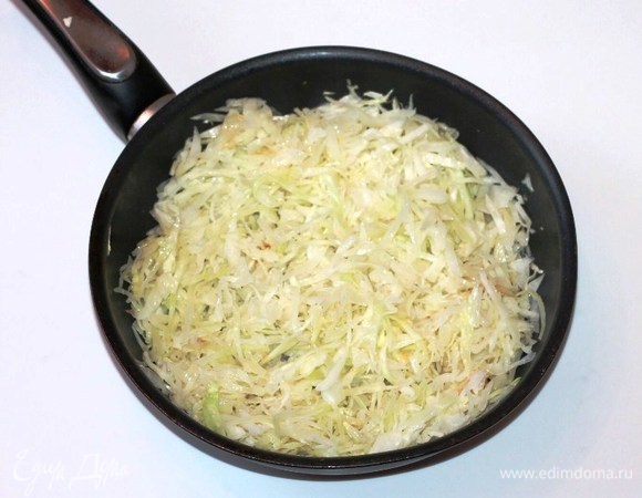 Подготовленную капусту нарезаем соломкой (700 г). Разогреваем в сковороде сливочное масло и выкладываем капусту.