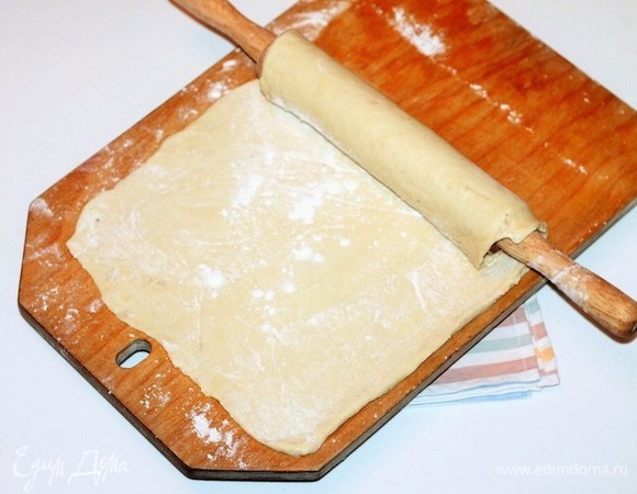 Одну часть теста раскатать в пласт по величине формы и перенести при помощи скалки.