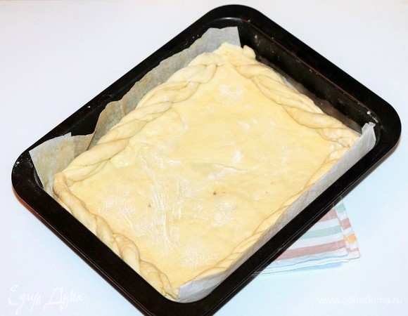 Край пирога смазать взбитым яйцом и выложить жгутиками из теста.