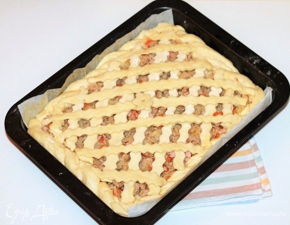 Раскатать третью часть теста в пласт и вырезать полоски. Закрыть начинку фигурными полосками из теста. Затем накрываем пирог легким сухим полотенцем и отправляем в теплое место для подъема в 2 раза.