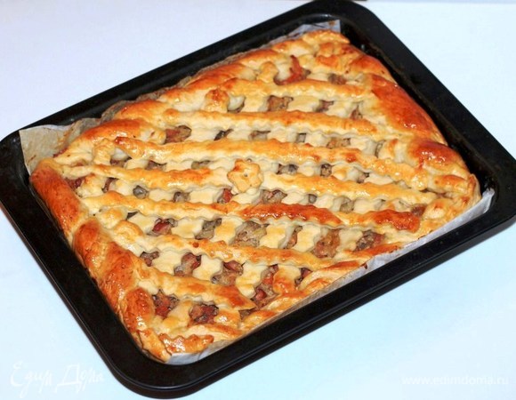 Смазываем пирог взбитым яйцом и выпекаем в хорошо разогретой до 180°C духовке 30–40 минут до румяной корочки.