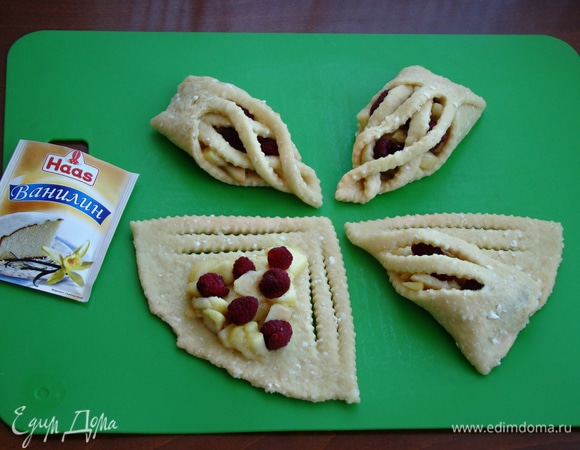 В середину треугольника положить яблочную начинку, сверху добавить малину. Каждый треугольник свернуть кулечком и защипнуть широкий край.