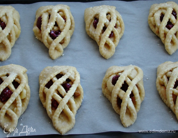 Плетенки уложить на противень, застеленный пекарской бумагой, и смазать яично-молочной смесью. Выпекать в разогретой до 180°C духовке примерно минут 30 до румяного цвета.