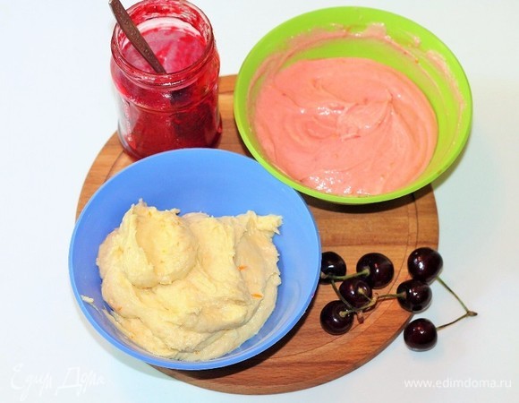 Делим тесто на 2 части. В одну миску добавляем протертое через сито варенье. Во вторую миску, если тесто очень густое, добавьте апельсиновый сок (1–2 ст. л.).